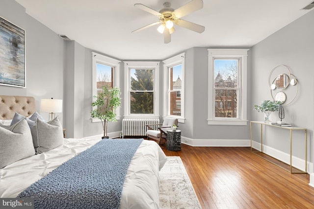 3218 13th St NW, Washington, DC 20010 - bedroom with radiator heating unit, wood finished floors, ceiling fan, baseboards, and visible vents