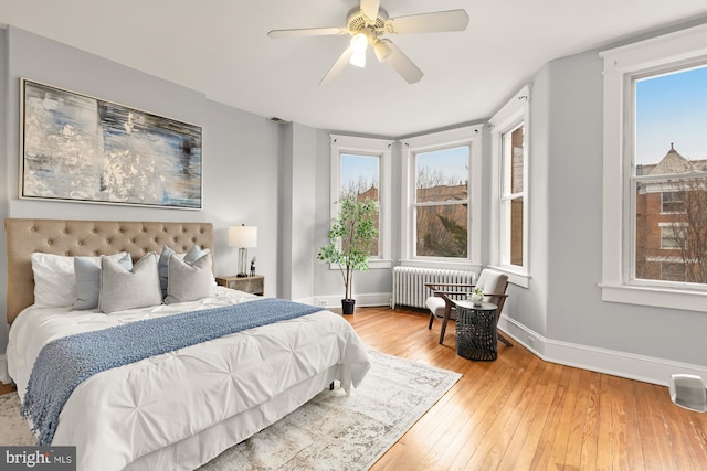 3218 13th St NW, Washington, DC 20010 - bedroom with radiator heating unit, baseboards, hardwood / wood-style floors, and multiple windows