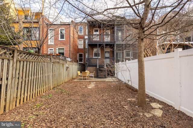 3218 13th St NW, Washington, DC 20010 - rear view of house featuring brick siding, a fenced backyard, and a balcony