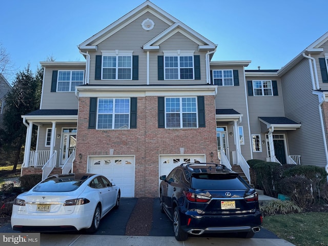 view of front of house with a garage, driveway, and brick siding