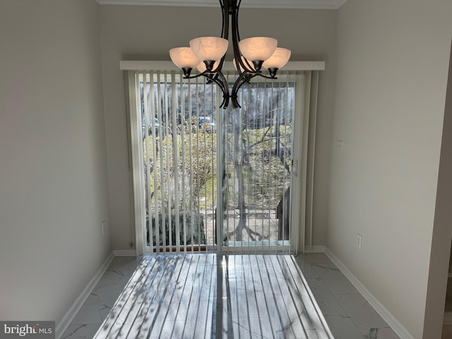 unfurnished dining area with a notable chandelier, marble finish floor, and baseboards