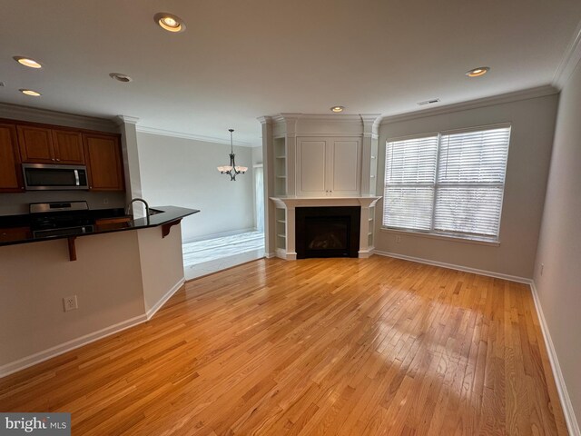 living area featuring crown molding, baseboards, an inviting chandelier, and light wood-style floors
