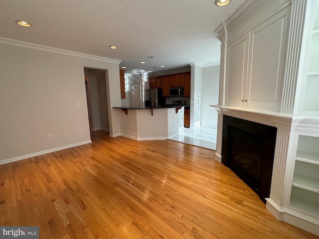 unfurnished living room with light wood-type flooring, baseboards, ornamental molding, and recessed lighting