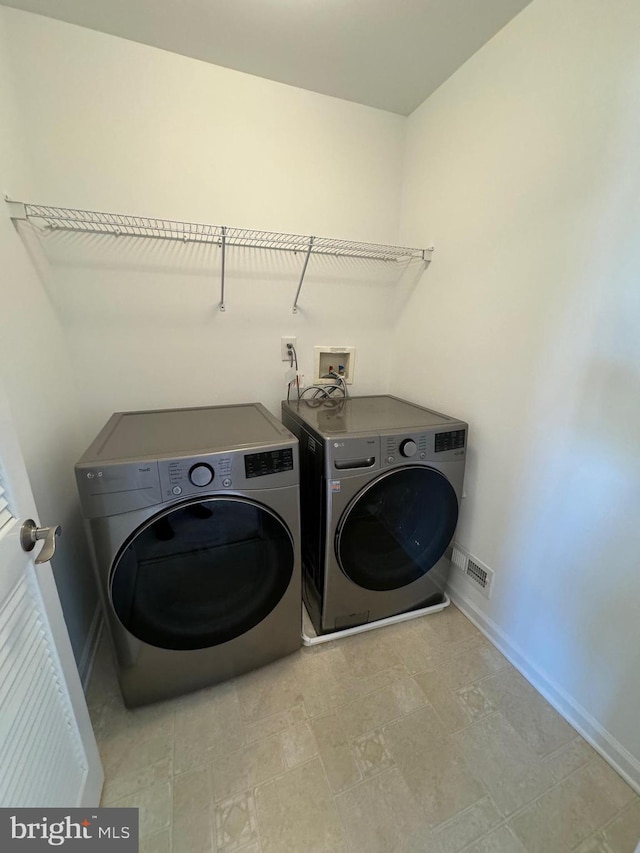 washroom with laundry area, separate washer and dryer, baseboards, and visible vents
