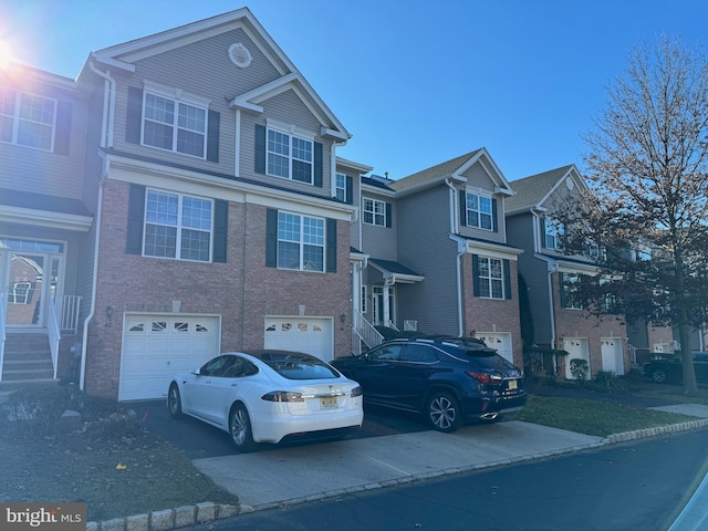 view of front of home featuring a garage, driveway, and brick siding