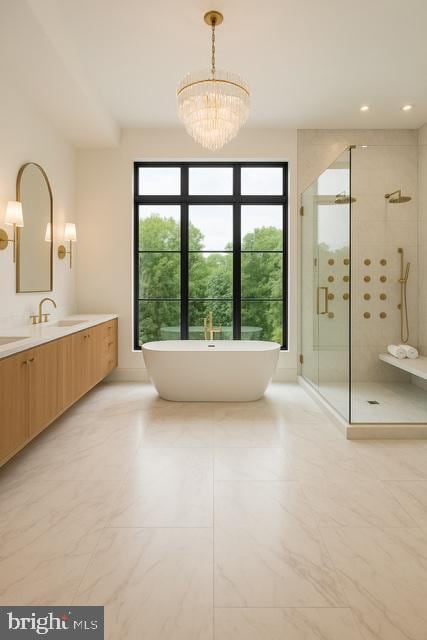 9210 Marseille Dr, Potomac, MD 20854 - full bath featuring a shower stall, vanity, a freestanding bath, marble look tiles, and a chandelier
