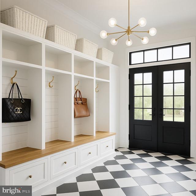 9210 Marseille Dr, Potomac, MD 20854 - mudroom featuring french doors, light flooring, and a chandelier