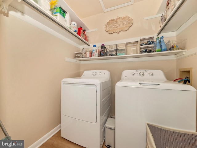 clothes washing area with baseboards, washing machine and dryer, and laundry area