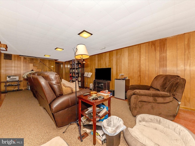 carpeted living area with wood walls