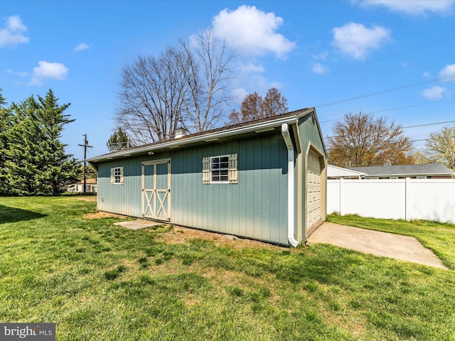 exterior space with an outdoor structure, fence, and driveway