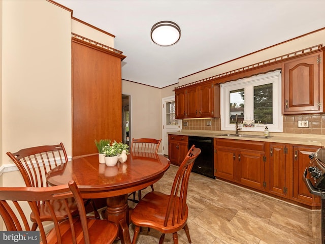 kitchen featuring dishwasher, light countertops, a sink, and decorative backsplash