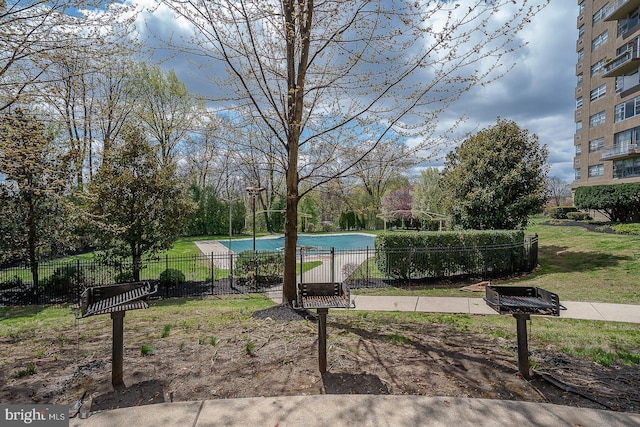 view of community with fence and a swimming pool