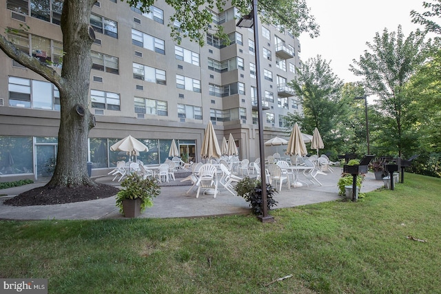 view of property's community with a lawn and a patio