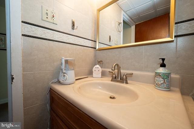 bathroom with vanity and tile walls