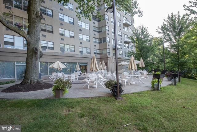 view of community featuring a lawn and a patio area