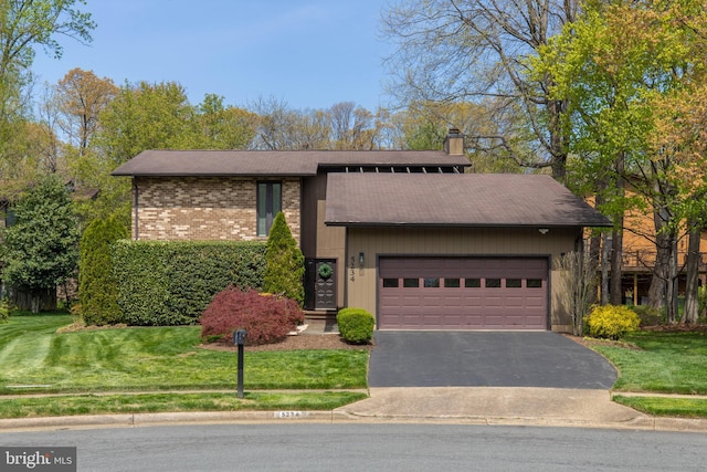 mid-century inspired home featuring a chimney, aphalt driveway, brick siding, a front yard, and a garage