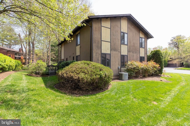view of side of property featuring a yard and central air condition unit