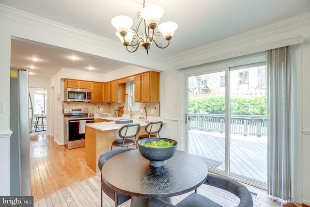 dining area featuring a notable chandelier, light wood-type flooring, and crown molding
