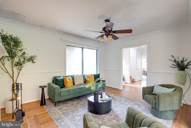 living room featuring ornamental molding, baseboards, a ceiling fan, and wood finished floors