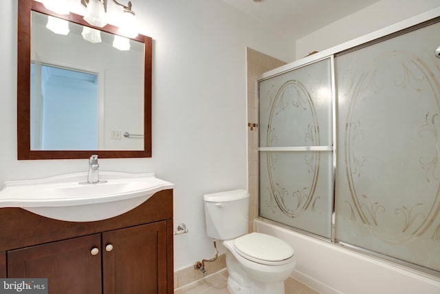 bathroom with combined bath / shower with glass door, toilet, vanity, and tile patterned flooring