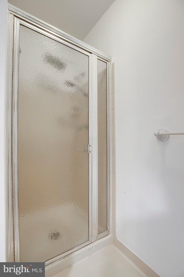 bathroom featuring a stall shower, baseboards, and tile patterned floors