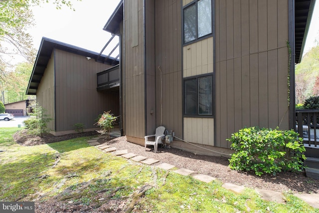 view of side of property with a lawn and a balcony
