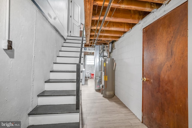 3660 Academy Rd, Philadelphia, PA 19154 - stairs featuring water heater, concrete block wall, and wood finished floors