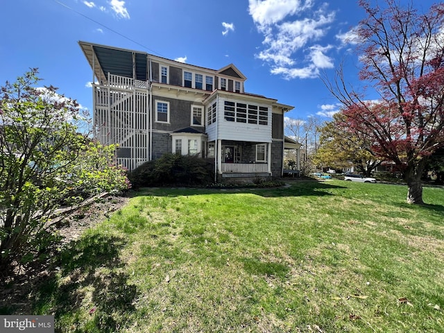 back of house featuring a yard and stairs