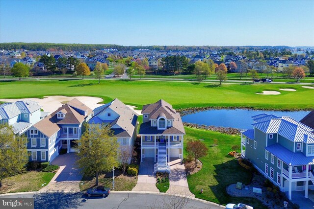 drone / aerial view featuring a residential view, golf course view, and a water view