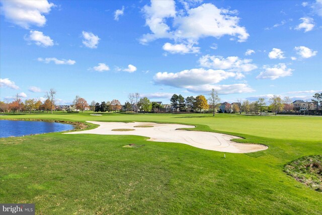 surrounding community featuring a lawn, view of golf course, and a water view