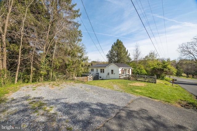 view of front of property with a wooden deck, a front lawn, and aphalt driveway