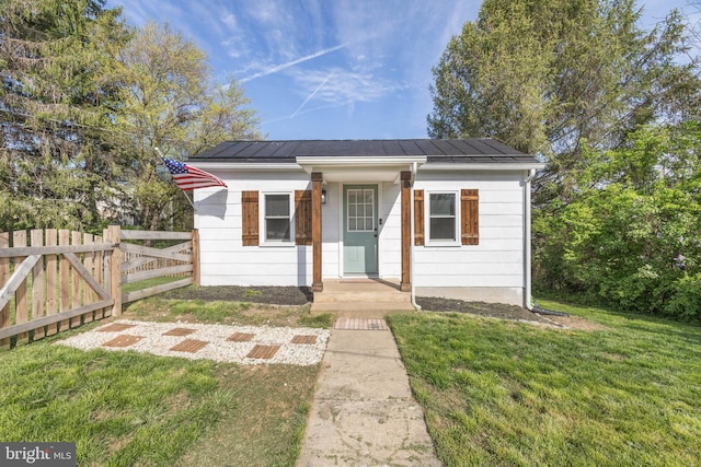 bungalow-style house with fence and a front lawn