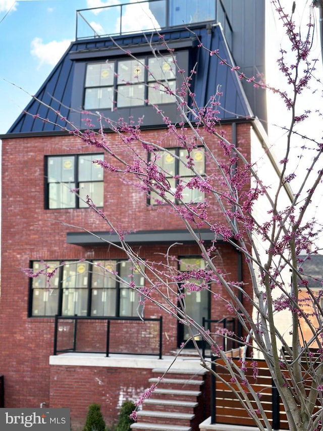view of front of home with brick siding and stairway