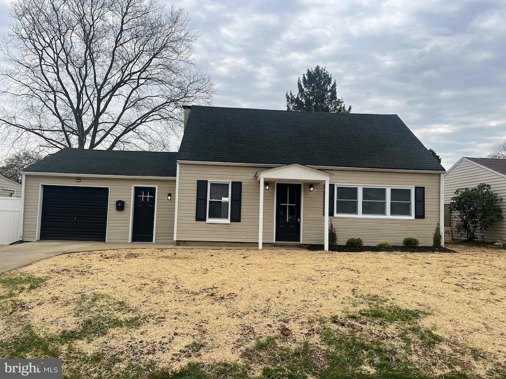 cape cod home with driveway and a garage