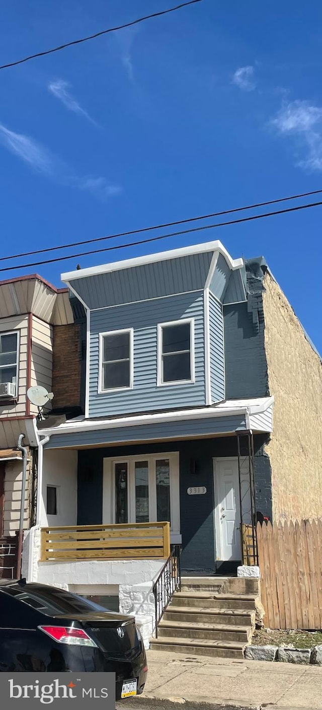 view of front of house with covered porch and fence