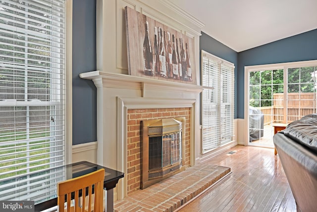 living room featuring a fireplace, wood-type flooring, and visible vents