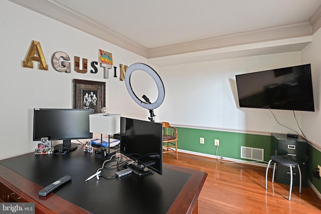 office area with wood finished floors, visible vents, baseboards, and ornamental molding