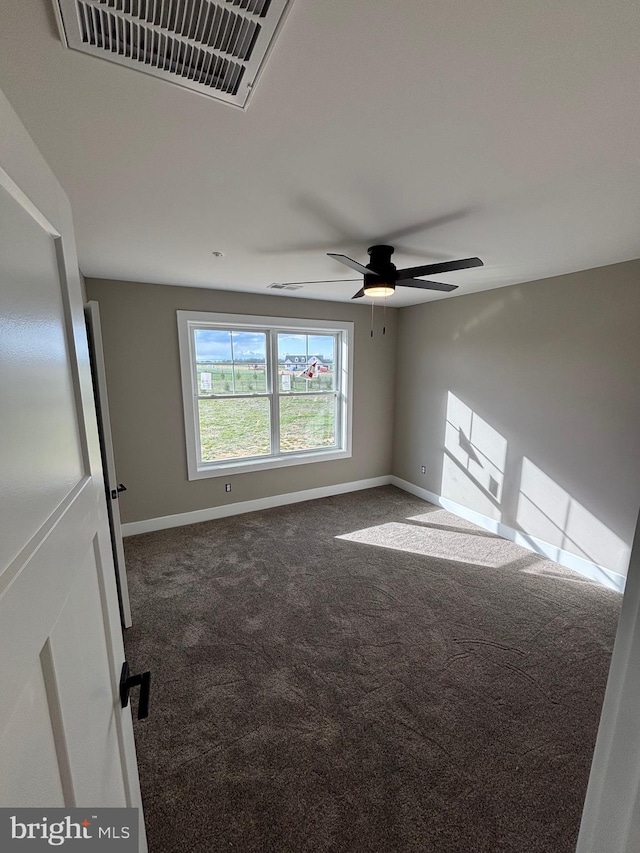 carpeted spare room featuring visible vents, baseboards, and ceiling fan