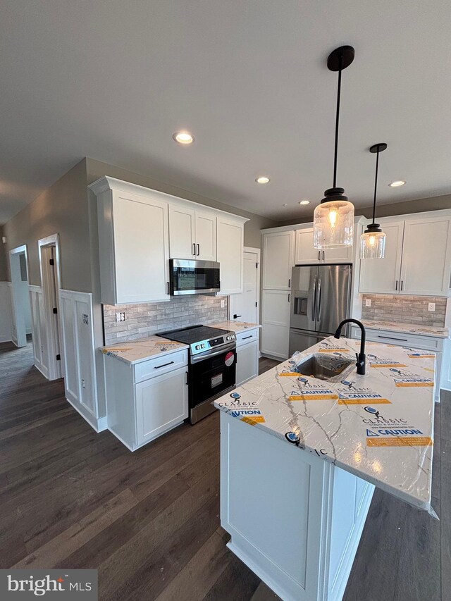 kitchen with white cabinets, dark wood finished floors, tasteful backsplash, and stainless steel appliances