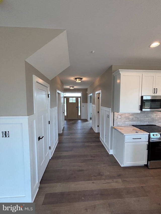 kitchen featuring appliances with stainless steel finishes, dark wood finished floors, white cabinetry, recessed lighting, and backsplash