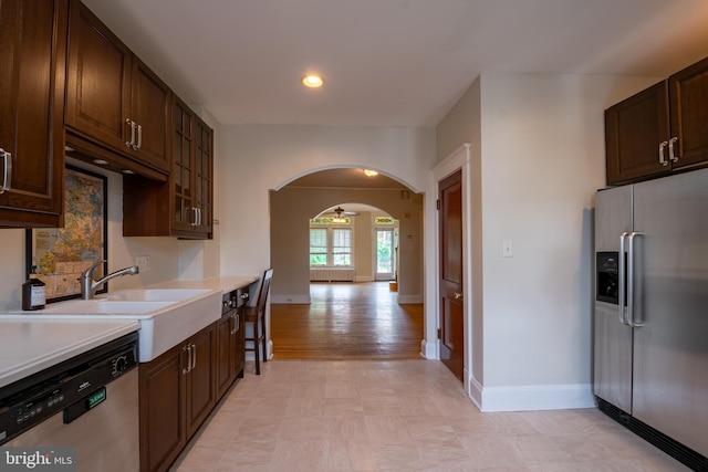 1323 W 41st St, Baltimore, MD 21211 - kitchen with stainless steel appliances, light countertops, dark brown cabinetry, arched walkways, and recessed lighting