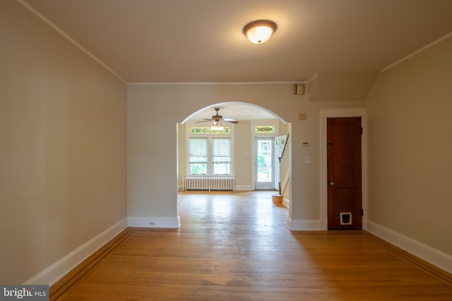 1323 W 41st St, Baltimore, MD 21211 - spare room with radiator, arched walkways, wood finished floors, crown molding, and baseboards