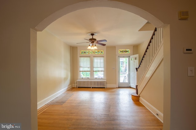 1323 W 41st St, Baltimore, MD 21211 - foyer featuring radiator, a ceiling fan, wood finished floors, arched walkways, and baseboards