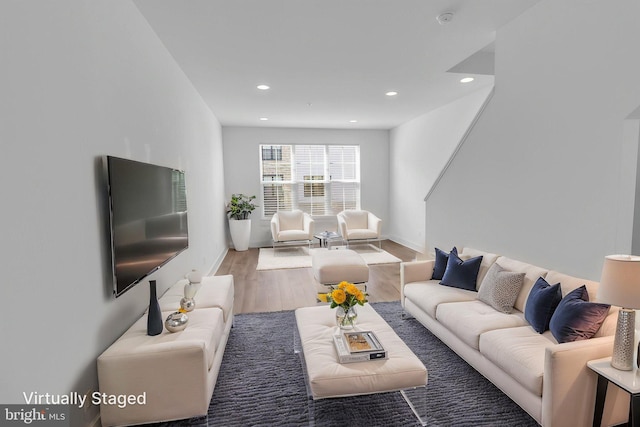 living room featuring baseboards, recessed lighting, and wood finished floors