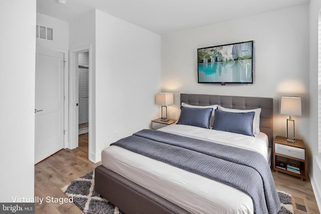 bedroom featuring wood finished floors, baseboards, and visible vents