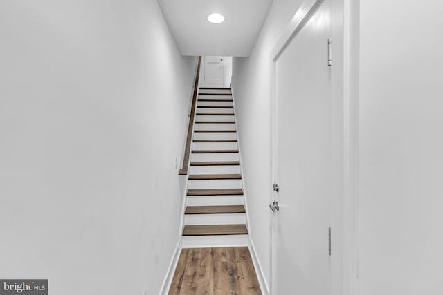 stairs with wood finished floors and baseboards