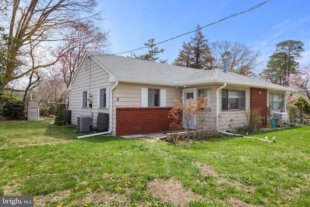14B Heron St S, Manchester Township, NJ 08759 - view of front facade featuring brick siding, cooling unit, roof with shingles, and a front lawn