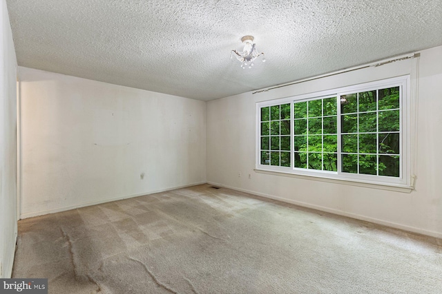 unfurnished room featuring carpet floors, baseboards, and a textured ceiling