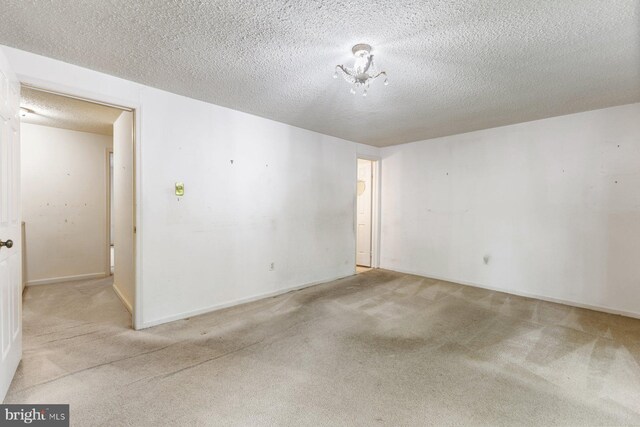 carpeted spare room featuring a textured ceiling