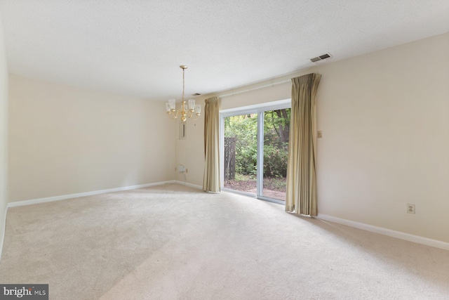 carpeted spare room with a chandelier and baseboards